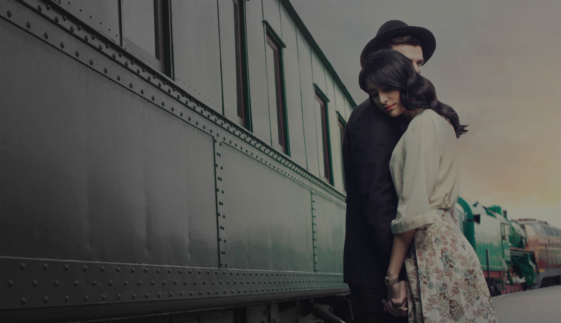 A couple standing in front of a passing by train